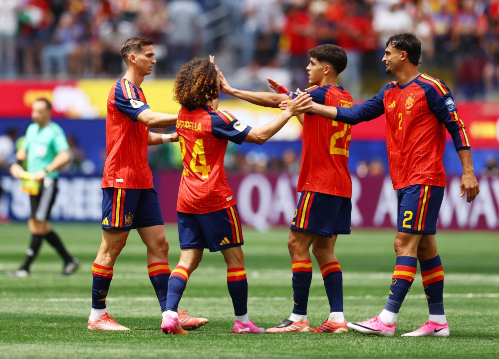  
Spain players celebrate after the match. — Reuters