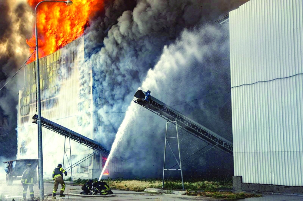 Firefighters work at the site of one of the biggest Ukrainian poultry farms which was hit by a Russian air strike in the town of Chornobaivka. — Reuters