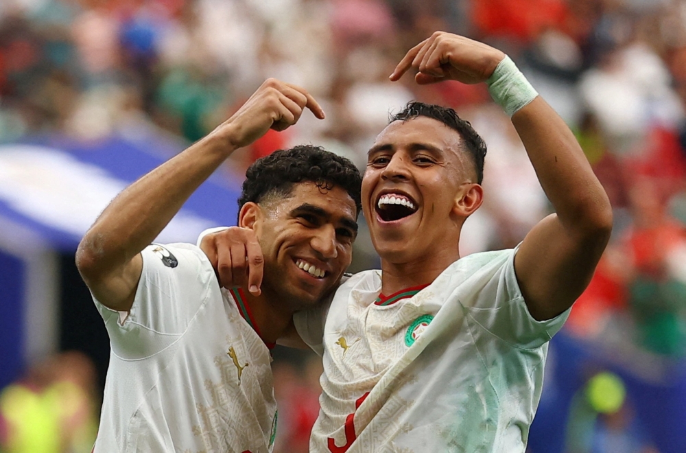  
Morocco's Soufiane Rahimi celebrates scoring their third goal with Achraf Hakimi  