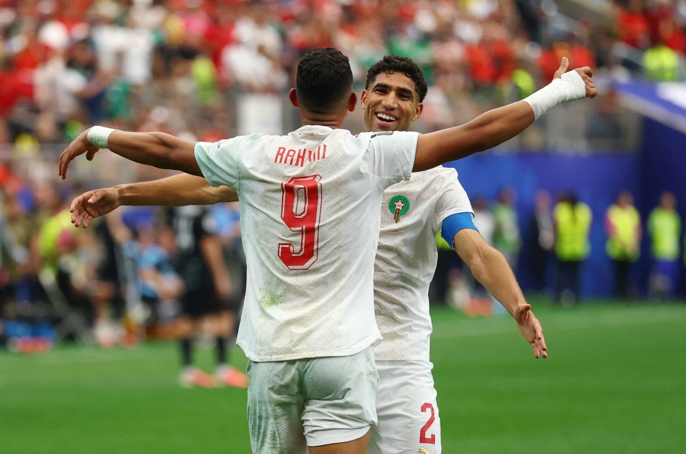  
Morocco's Soufiane Rahimi celebrates scoring their third goal with Achraf Hakimi  