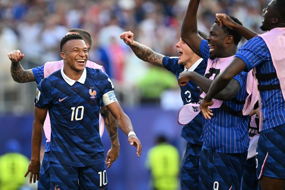 France's forward #10 Kylian Mbappe celebrates with teammates after winning 
