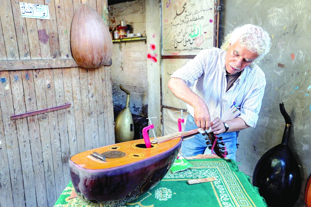 Palestinian craftsman Suhail Abu Shawish bends carefully over a battered oud, tuning its strings after days of painstaking repair.— AFP