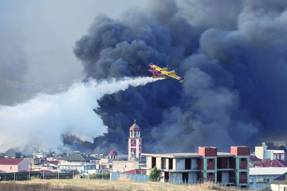 A Canadair firefighting plane drops water at a burning recycling factory in Oreokastro, on the outskirts of Thessaloniki, Greece. — Reuters 