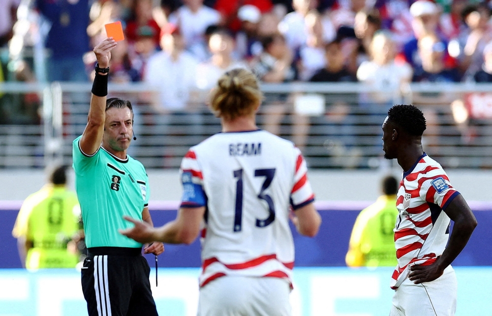  
Folarin Balogun of the U.S. is shown a red card by referee Raphael Claus during the match between USA and Paraguay  