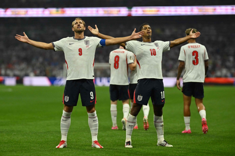 England's midfielder #10 Jude Bellingham celebrates scoring his team's first goal with England's forward #09 Harry Kane  