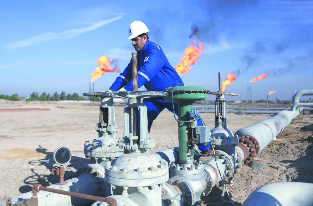 An Iraqi worker operates valves in Nihran Bin Omar field north of Basra, Iraq. — Reuters