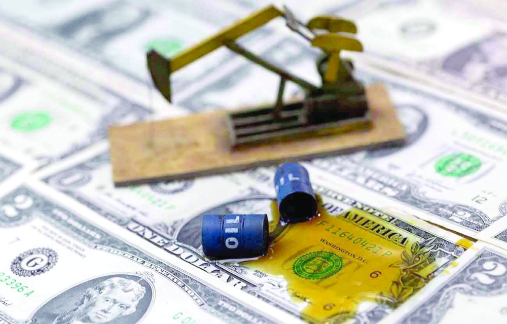 A 3D-printed oil pump jack and oil barrels are placed on dollar banknotes in this illustration picture. — Reuters