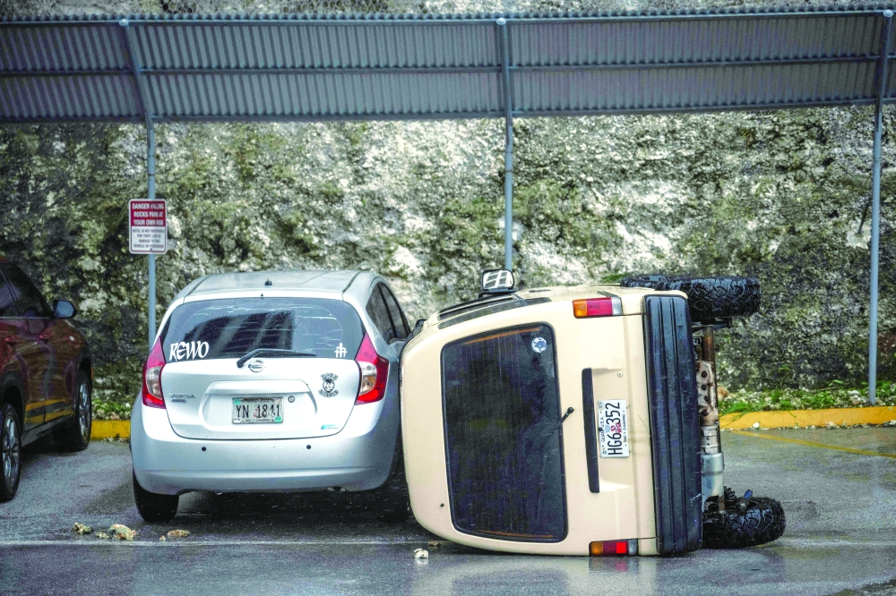 A car lies overturned after being flipped by strong winds brought by Super Typhoon Bavi in Guam. — AFP