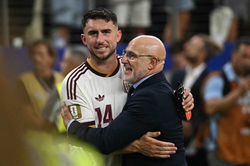 Spain's head coach Luis de la Fuente and defender #14 Aymeric Laporte react  