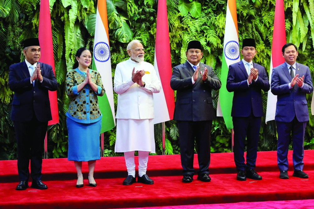 (C) Indian PM Narendra Modi, along with Indonesian President Prabowo Subianto, applauds as they pose for group photos at Indonesian Parliament building in Jakarta. — Reuters