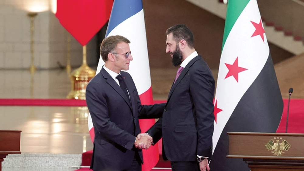 France's President Emmanuel Macron and Syrian President Ahmed al Sharaa shake hands on the day they meet in Damascus. — Reuters