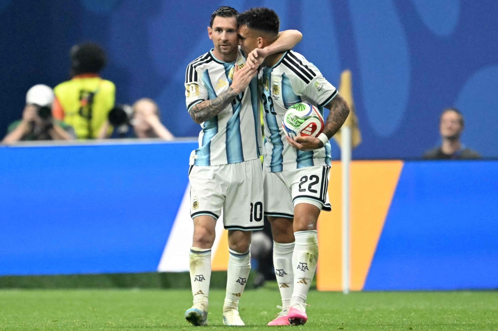 Argentina's forward #10 Lionel Messi and Argentina's forward #22 Lautaro Martinez celebrate after Argentina's midfielder #24 Enzo Fernandez scored his team's third goal  