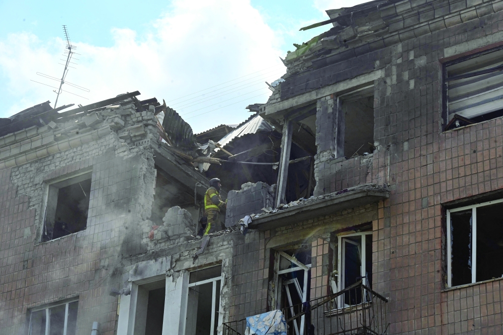 Rescuers search the rubbles of a damaged residential building in Kharkiv. — AFP