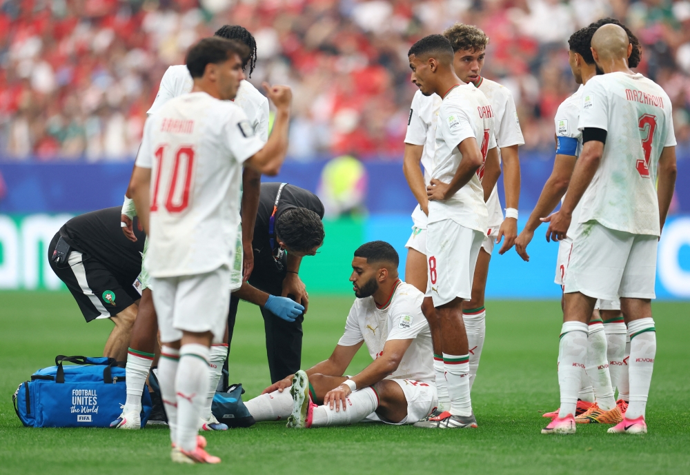  
Morocco's Ismael Saibari receives medical attention after sustaining an injury before being substituted  