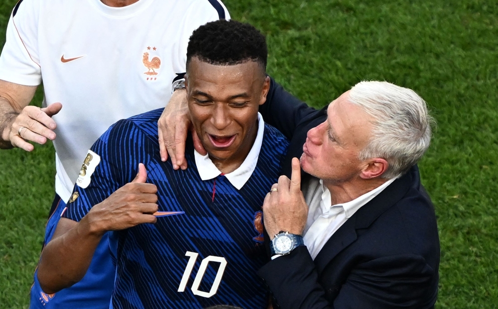 France's #10 Mbappe celebrates with coach Deschamps after Paraguay match. — AFP
