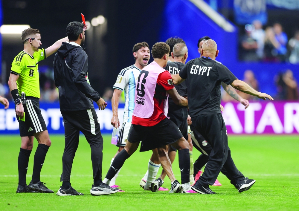 A member of Egypt's coaching staff is shown a red card by referee Francois Letexier. — Reuters