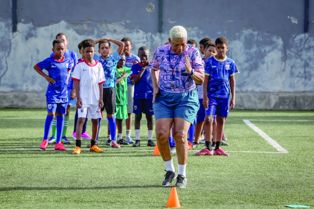 Silveria Nedio, 60, head coach at Bola Pra Frente football academy and head coach of Cape Verde women's national football team, demonstrates for youth trainees during a football training session at Bola Pra Frente academy in Praia, Cape Verde. — Reuters
