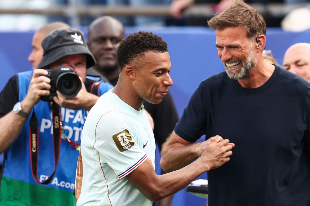 France's forward #10 Kylian Mbappe (L) and German coach Jurgen Klopp talk 
