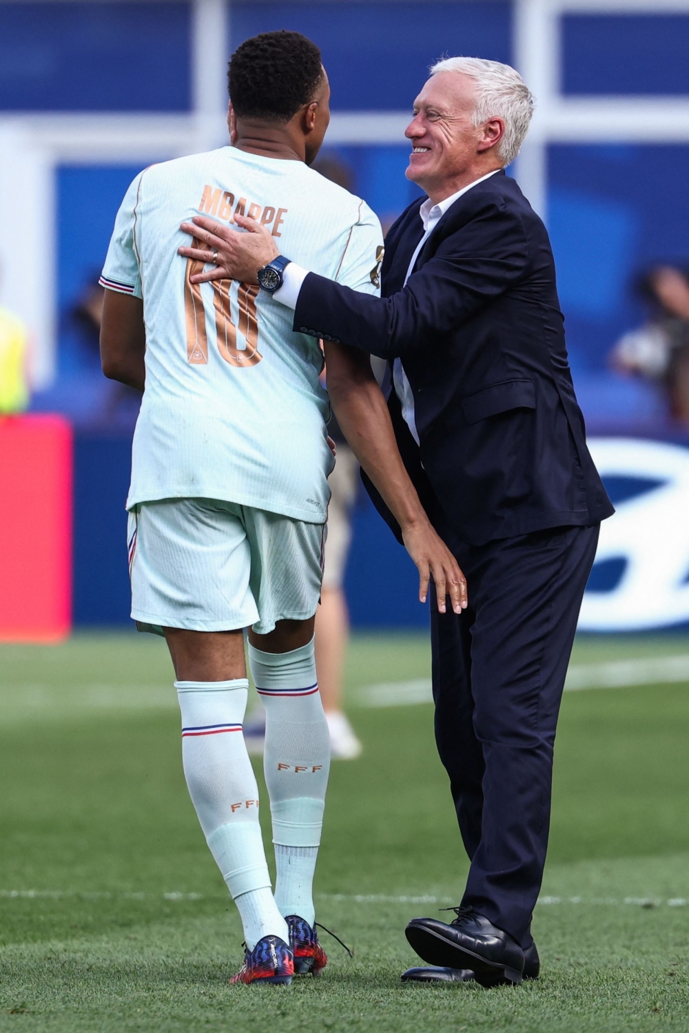 France's forward #10 Kylian Mbappe and head coach Didier Deschamps hug  