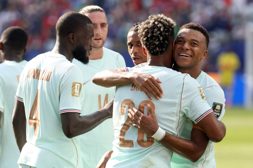 France's forward #10 Kylian Mbappe (R) celebrates scoring his team's first goal with teammate forward #20 Desire Doue  