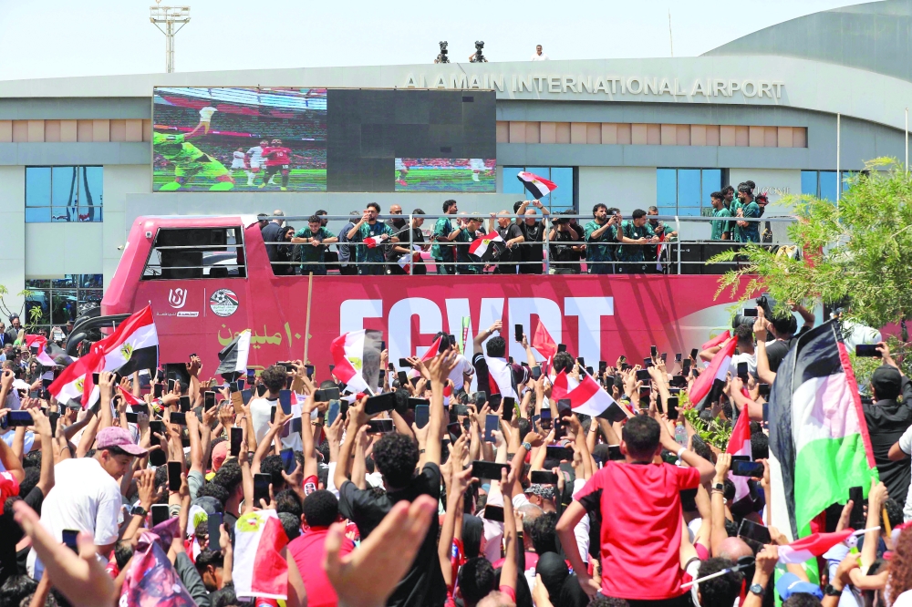 Egypt's players wave from an open-top bus as supporters gathered to welcome them at El-Alamein International Airport in the northern coastal city of El-Alamein. — AFP