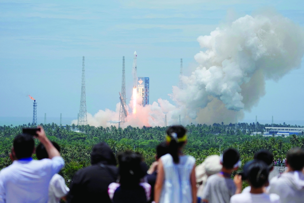 People watch as a Long March 10B carrier rocket takes off from Wenchang Spacecraft Launch Site, in Hainan province, China. — Reuters