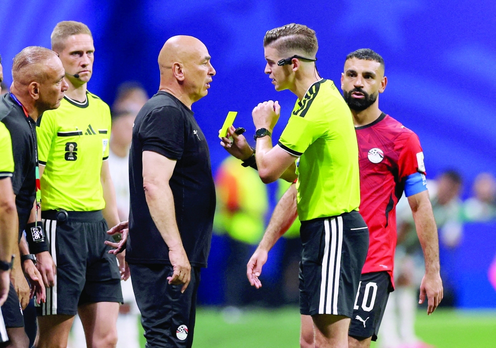 Egypt coach Hassan is shown a yellow card by referee Letexier. — Reuters