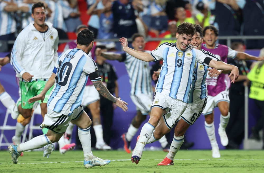 Argentina's forward #09 Julian Alvarez celebrates scoring his team's second goal with Argentina's forward #10 Lionel Messi and Argentina's defender #06 Lisandro Martinez  
