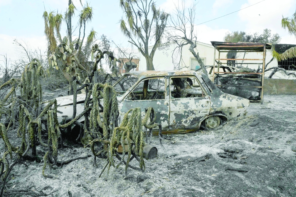 A burnt car that was damaged in the wildfire is seen in Almocaizar, Almeria Province. — AFP