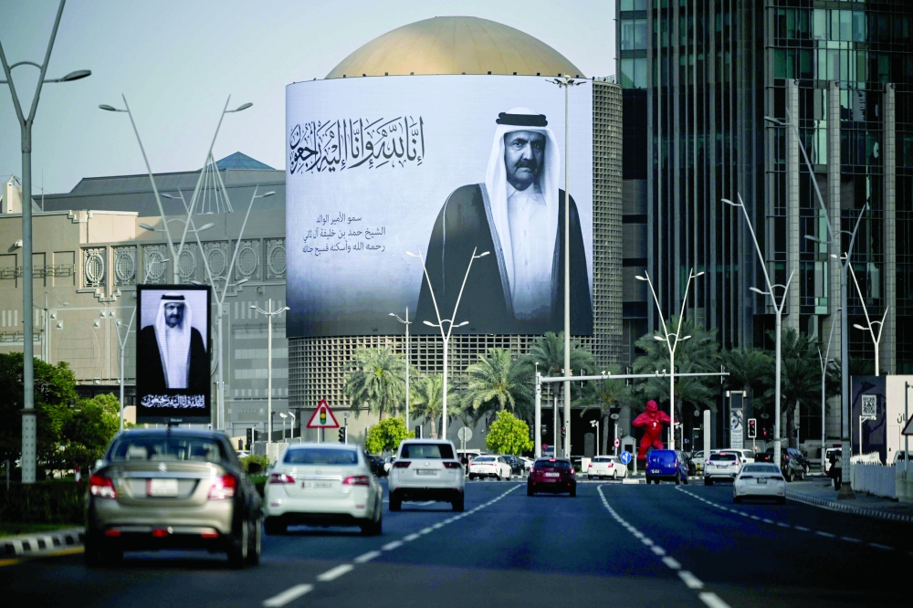 Commuters drive past a billboard bearing a portrait of Qatar's former leader Sheikh Hamad bin Khalifa Al Thani in Doha. — AFP