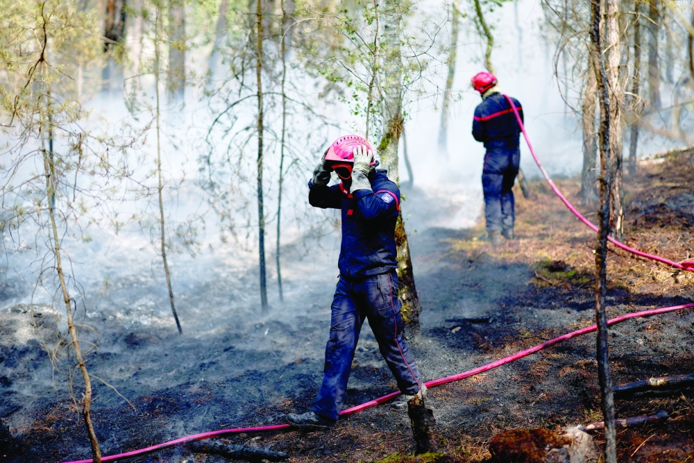 French firefighters work to extinguish a wildfire in the Fontainebleau forest, during a heatwave affecting a large part of the country, in Noisy-sur-Ecole, France, July 14, 2026. REUTERS/Stephane Mahe