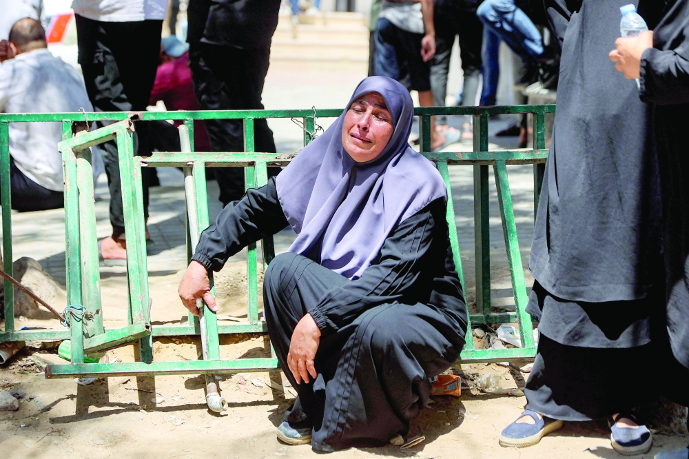 A woman reacts during the funeral for several victims killed after a police station was was hit by Israeli bombardment in the Jabalia camp for Palestinian refugees in the northern Gaza Strip, in Gaza City on July 14, 2026. Gaza's civil defence agency and the hospital said that the Israeli airstrike on the police station in northern Gaza killed eight people on July 14, including a woman officer. In a statement condemning the strike, Palestinian Islamist movement Hamas, which controls Gaza's police force, said that the police station chief was among those killed. (Photo by Omar AL-QATTAA / AFP)