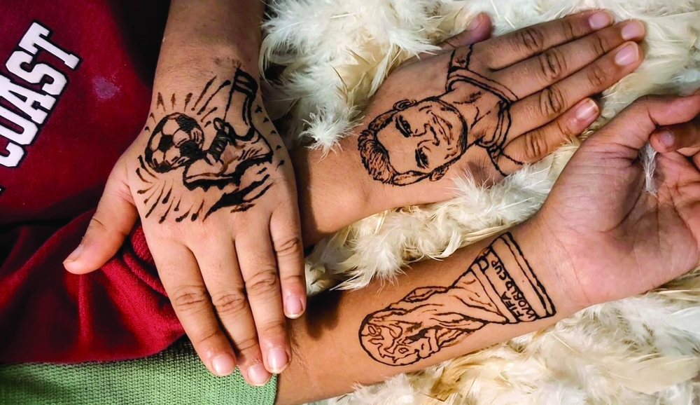 Faseela Shoukkath, a housewife living in Oman, is painting Messi, Ronaldo, and Mbappé on the hands of fans who want more.