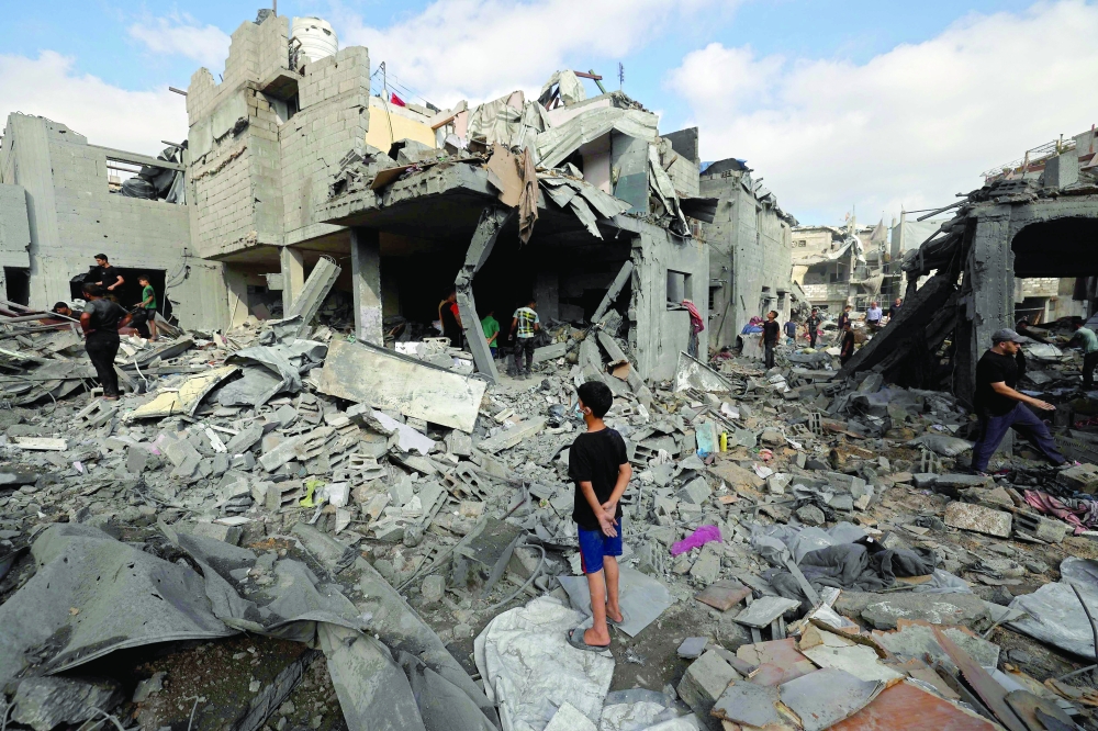 Palestinians inspect the site of an Israeli strike at the Bureij refugee camp in central Gaza Strip on Thursday.  — AFP