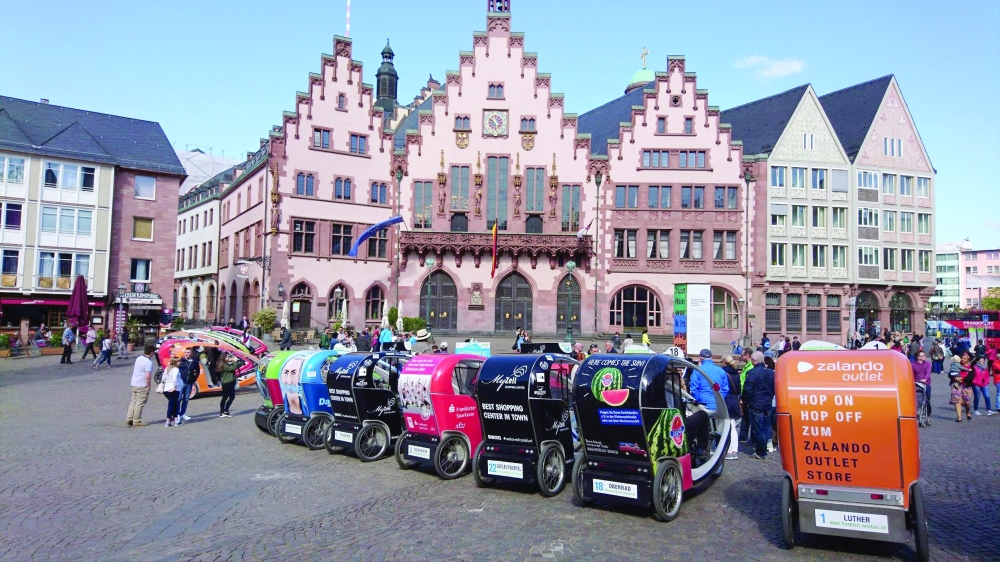 A colourful Velotaxi waits near the Römer, a symbol of Frankfurt’s historic charm