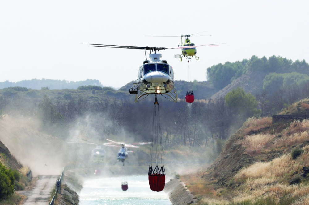 Firefighting helicopters load water to battle wildfires affecting Zaragoza province, in Farasdues, Spain
