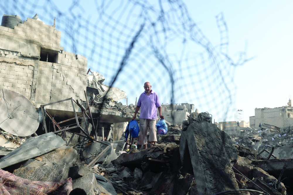 A Palestinian man inspects the site of an Israeli strike at the Bureij refugee camp in central Gaza Strip