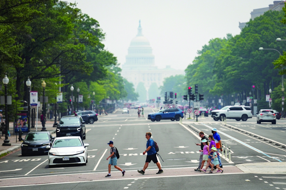 Pedestrians cross Pennsylvania Avenue near the US Capitol in smoky conditions due to the Canadian wildfires. — Reuters 