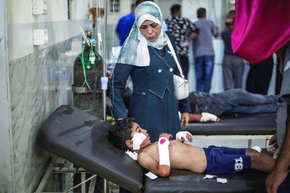 A young Palestinian boy lies injured at Al-Awda Hospital following a strike on the Nuseirat refugee camp in central Gaza. — AFP
