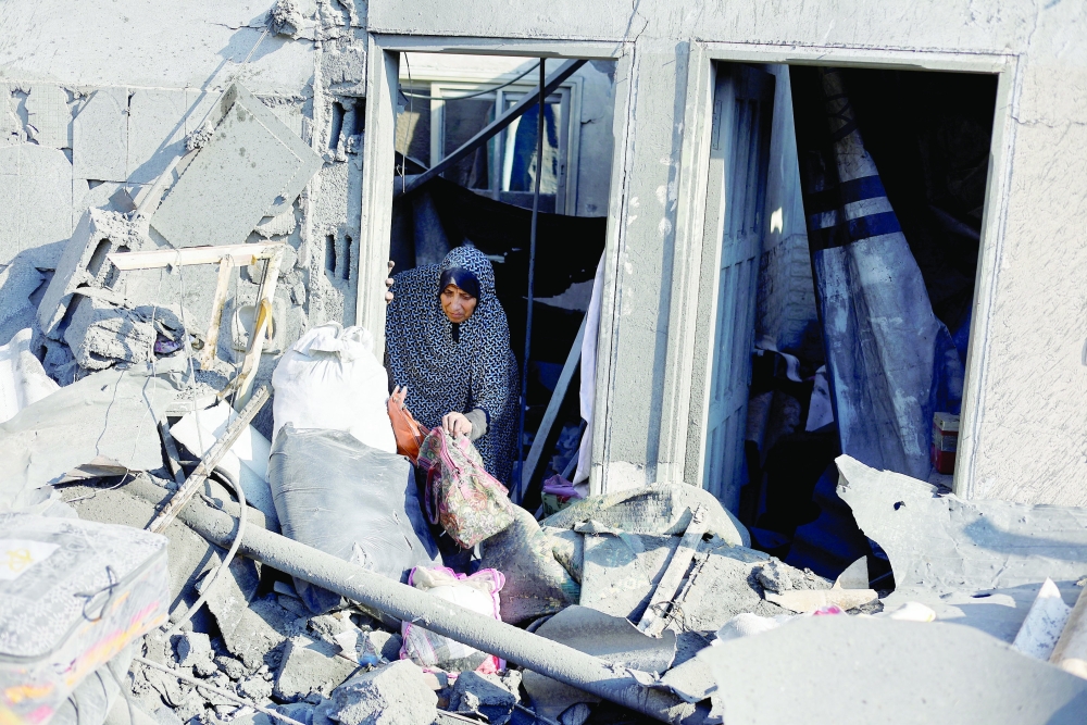 A Palestinian woman inspects the site of an Israeli strike on a house in the Nuseirat refugee camp, Gaza. — Reuters