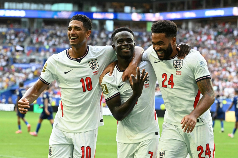 TOPSHOT - England's forward #07 Bukayo Saka (C) celebrates scoring his team's fifth goal with teammates midfielder #10 Jude Bellingham and defender #24 Reece James 