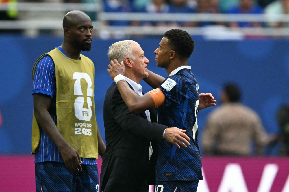 France's head coach Didier Deschamps (C) talks to France's forward #10 Kylian Mbappe after losing  
