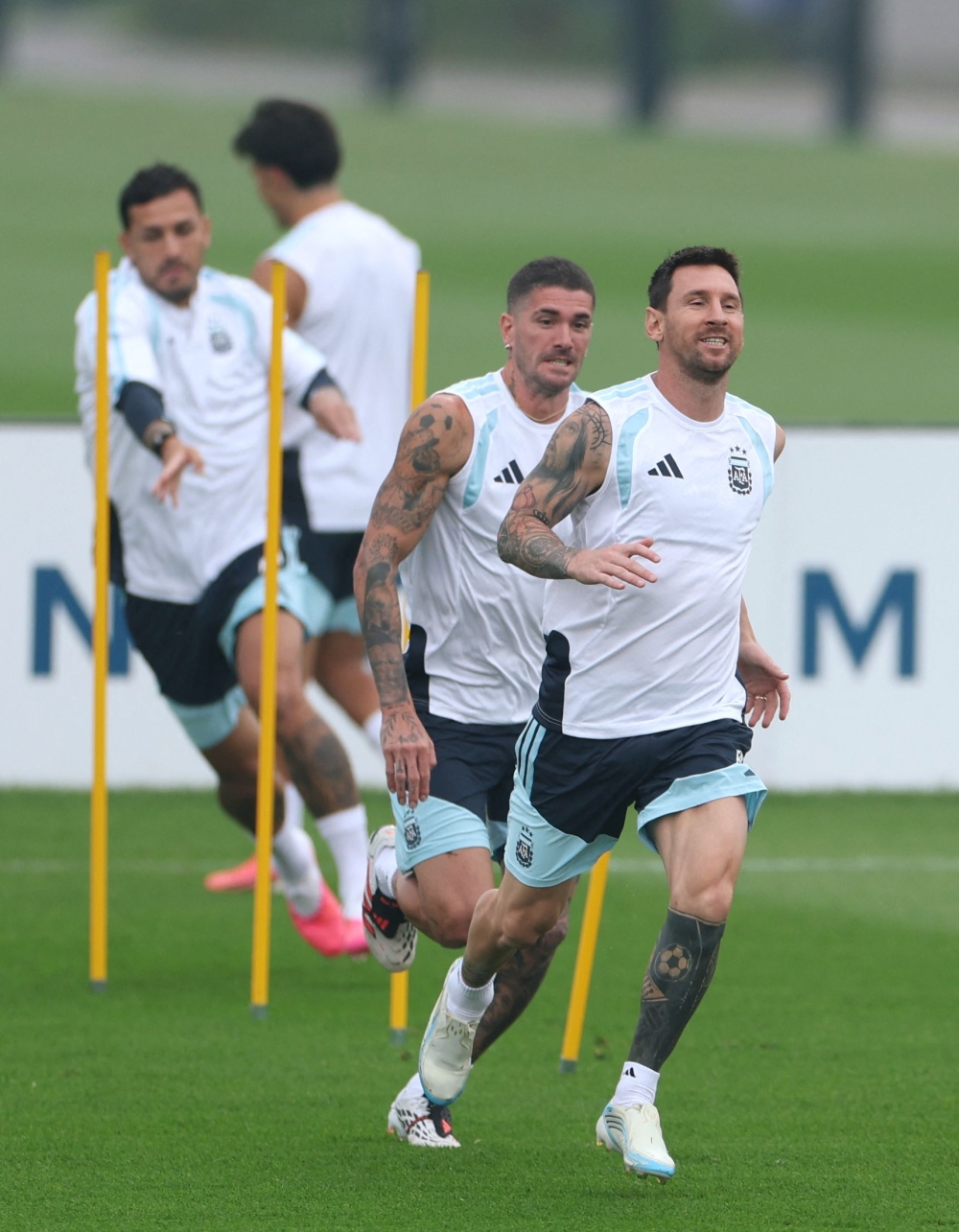 Argentina's forward #10 Lionel Messi (R) exercises followed by midfielders #07 Rodrigo De Paul and #05 Leandro Paredes 