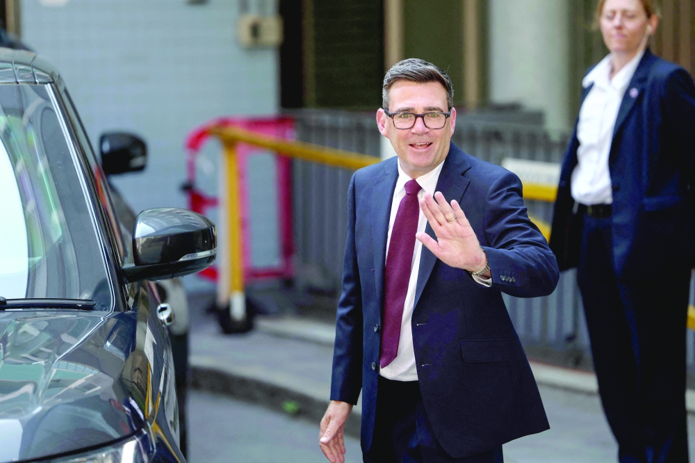 Andy Burnham waves as he leaves Labour’s 'Special Conference' in central London. — AFP