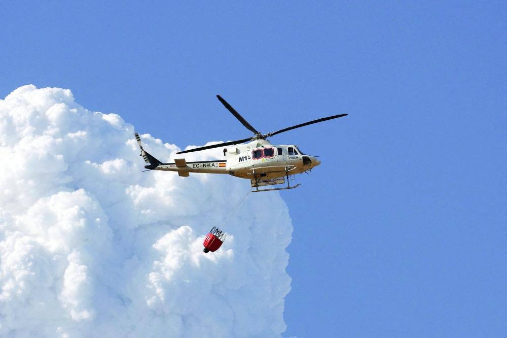 A helicopter flies amid wildfires affecting Farasdues, Spain. — Reuters 
