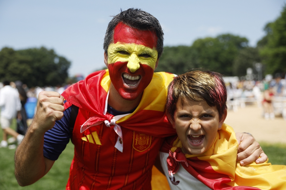  
Spain fans, one with his face painted in the national colours. — AFP