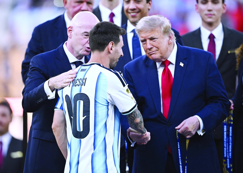  
Argentina's Lionel Messi shakes hands with U.S. President Donald Trump receiving collecting his runners up medal during the trophy presentation as FIFA President Gianni Infantino looks on  