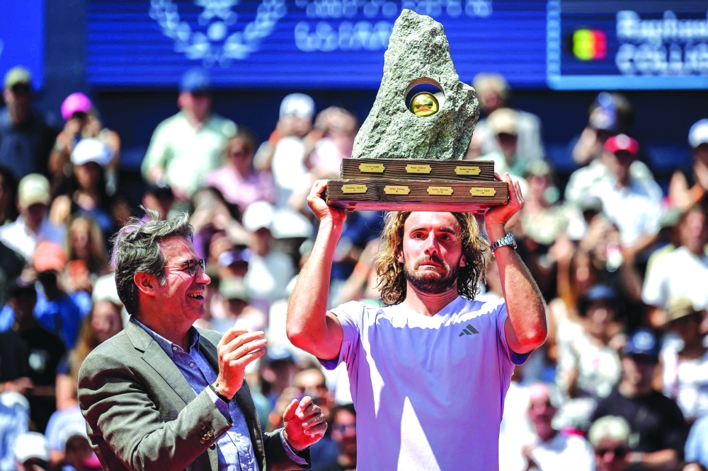 Greece's Stefanos Tsitsipas gestures as he raises the trophy. — AFP