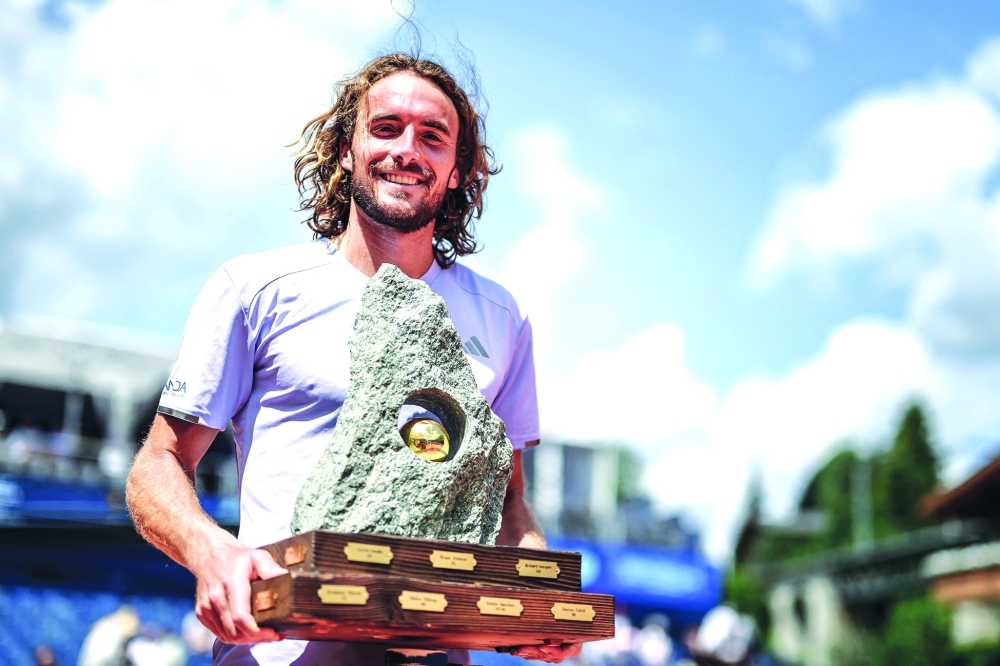 Greece's Stefanos Tsitsipas gestures as he raises the trophy. — AFP