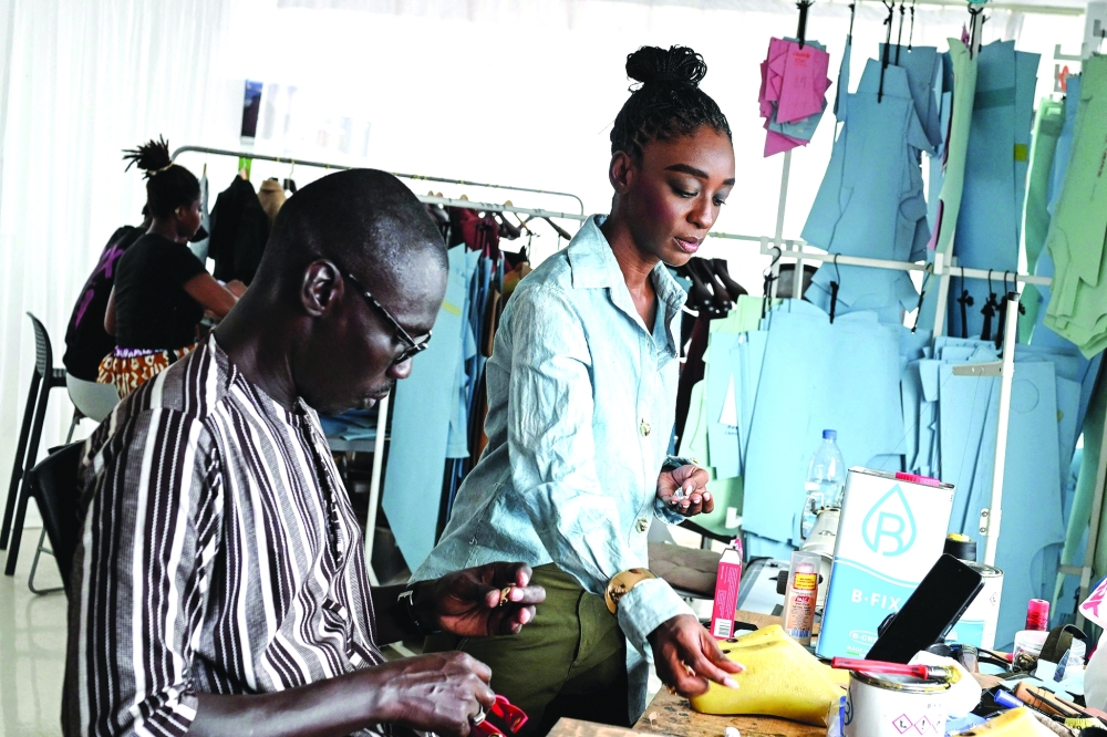 Ivorian Fashion designer Loza Maleombho interacts with a worker at her workshop in Treichville, a popular district of Abidjan— AFP
